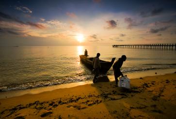 Fisherpeople come in at sunset at Sergang Laut. Flickr/Haryadi B