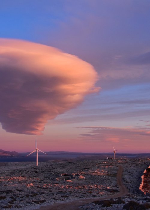 Cloud in sky above wind turbines.