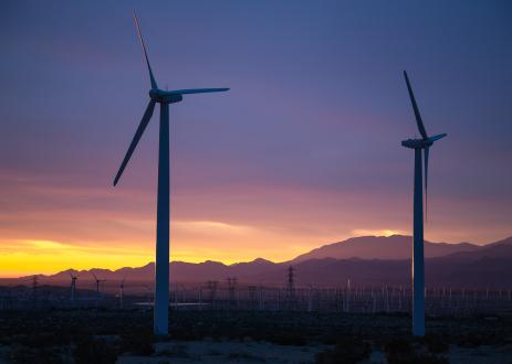 Windmills in front of mountains at sunset