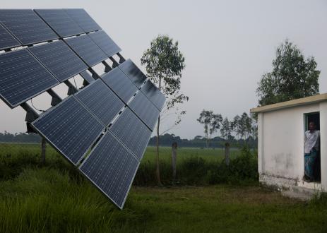Man in rural landscape looking at solar panel