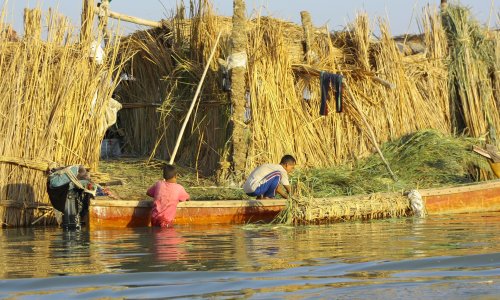 People near reed houses in the Ahwar of Southern Iraq.