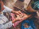 An Indigenous women hand cracking Brazil nuts