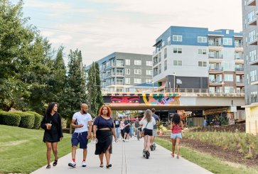 People walk along a paved walkway along the Atlanta Beltline.
