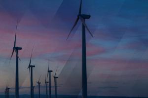 Windmills are framed by a pink and blue sky