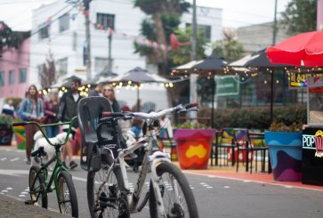 Bikes parked up in a bike lane with people walking on pedestrianized streets in the background in San Felipe, Bogotá.