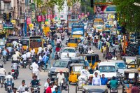 People and vehicles on a crowded street in India.