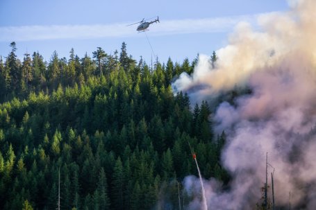 A helicopter drops water on a forest fire in British Columbia, Canada