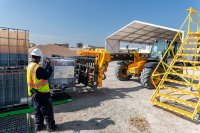 A man directs heavy equipment as part of Charm Industrial's bio-oil production.