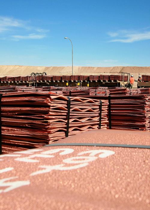 Two men checking train with copper cathodes for dispatch in Escondida, Chile