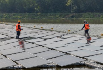Workers clean floating solar panels.