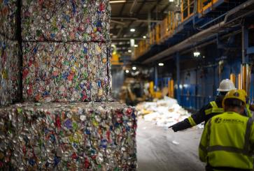 Two recycling facility workers next to bales of aluminum cans. Photo by Aaron Minnick | WRI.
