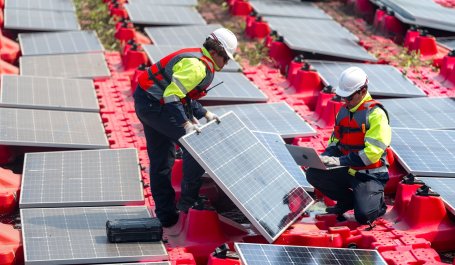 Workers install solar PV panels.