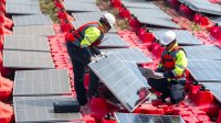 Workers install solar PV panels.