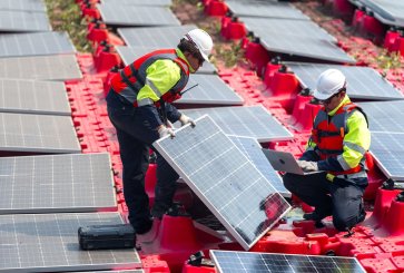 Workers install solar PV panels.