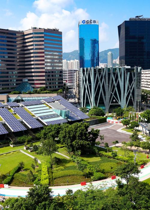Solar panels in park surrounded by skyscrapers