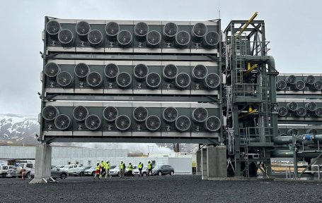 Direct air capture units at a Climeworks facility in Iceland with snow-capped mountains in the background.