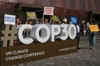 People hold signs protecting climate change outside of the UN climate summit venue.