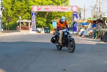 Person riding motorcycle in India during coronavirus pandemic