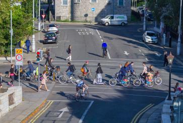 Cyclists and pedestrians on a street in Dublin.