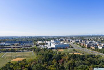 Aerial view of a large data center campus near homes and a playfield.