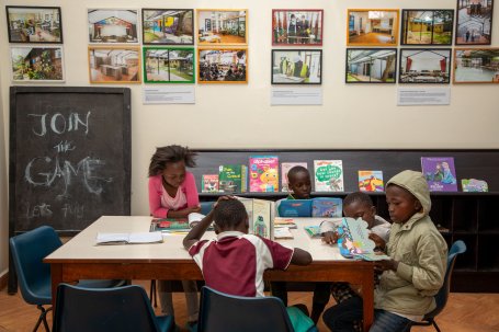 Students sit around a table while reading.