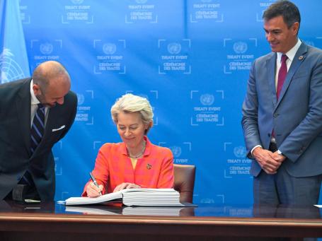 Ursula von der Leyen, president of the European Commission, signs the High Seas Treaty as Prime Minister Pedro Sánchez of Spain watches.