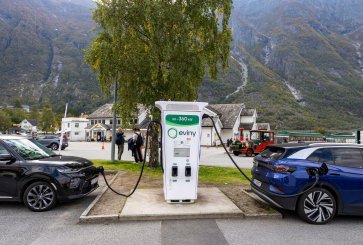 Two electric cars plugged in at a charging station. 
