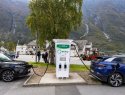 Two electric cars plugged in at a charging station. 
