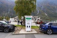 Two electric cars plugged in at a charging station. 