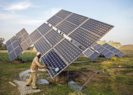 Farm worker clean the solar panels of a solar water pump at the farm.
