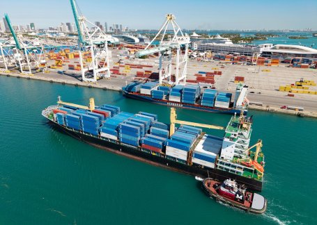 Shipping vessel with cargo containers at a port. 