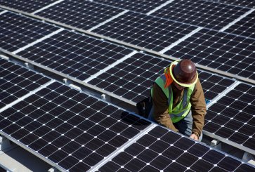 Technician installing solar panels on roof.
