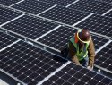Technician installing solar panels on roof.