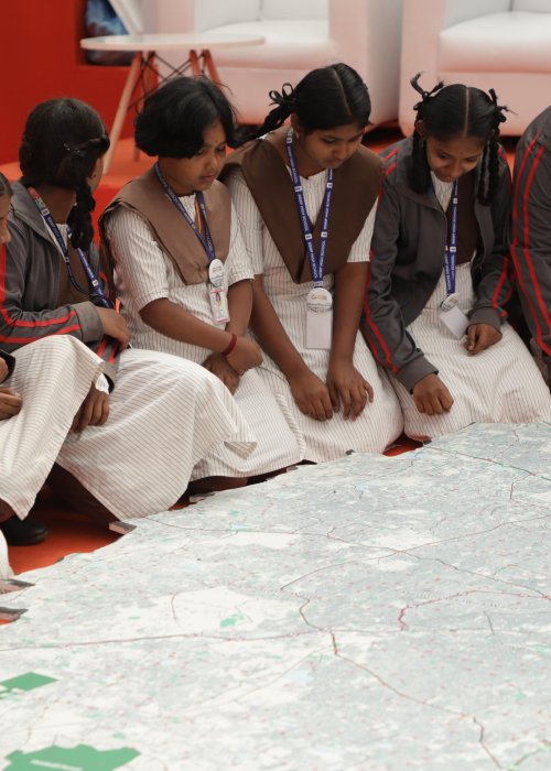 Girls sitting in front of map