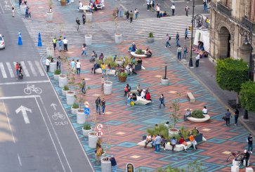 Pedestrians sitting on benches and walking near Zocalo square in Mexico City
