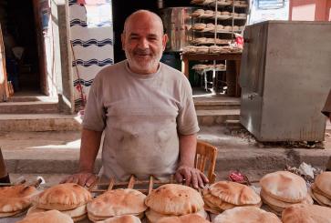 Baker standing in front of pita breads