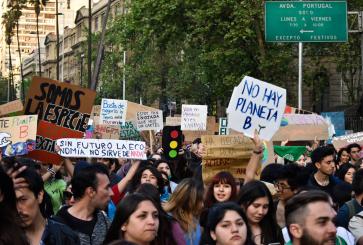 Climate change protesters holding signs in Spanish