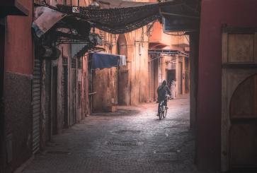 Person riding bicycle down brick street
