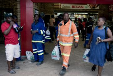 Men in safety attire walking with others out of store