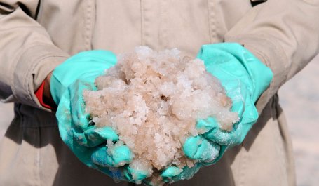 Gloved hands holding lithium-rich brine.
