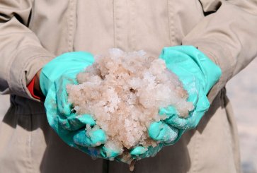 Gloved hands holding lithium-rich brine.