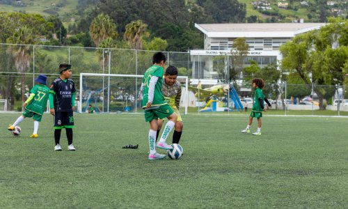 Several soccer players play a game on a field in Loja.