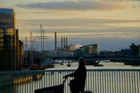 A person bikes across a bridge at dusk.