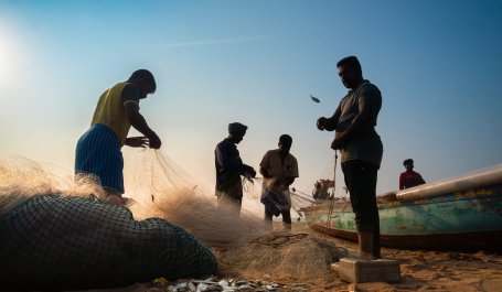 Men with fishing nets on beach.