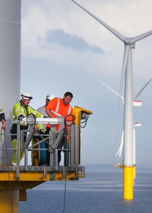 Workers on an offshore wind turbine tower.