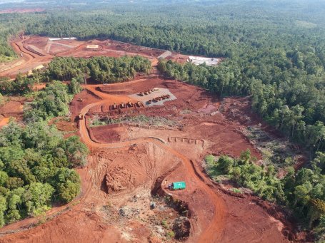 Large mining operation cut out of a forest with roads and excavators.