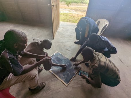 People crouch down to look at a map during a workshop.