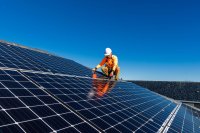 Worker installing a solar panel array. 