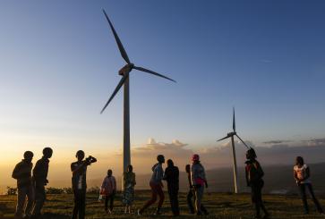 People in front of wind turbines.