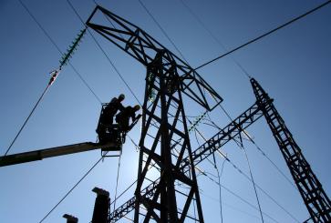 Two powerline workers in a lift. 